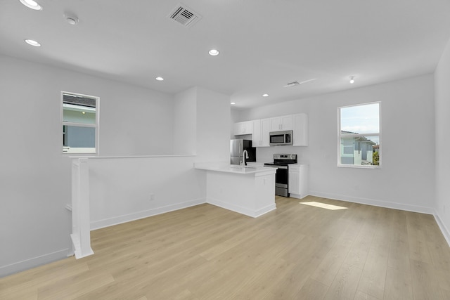 13496 Bernoulli Way, Palm Beach Gardens, FL 33418 - kitchen featuring stainless steel appliances, a peninsula, white cabinetry, recessed lighting, and light countertops