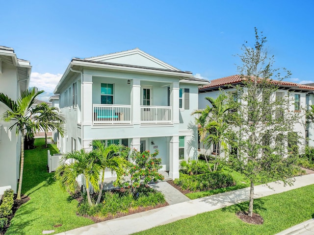 13496 Bernoulli Way, Palm Beach Gardens, FL 33418 - view of front of house with stucco siding, a front yard, and a balcony