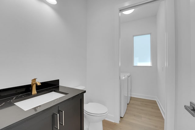 13496 Bernoulli Way, Palm Beach Gardens, FL 33418 - bathroom featuring washing machine and clothes dryer, wood finished floors, and vanity