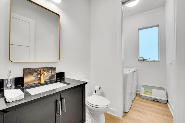 13496 Bernoulli Way, Palm Beach Gardens, FL 33418 - bathroom with washing machine and dryer, wood finished floors, and vanity