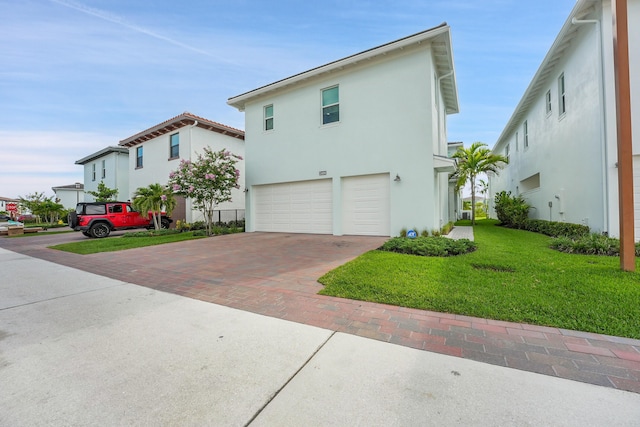 13496 Bernoulli Way, Palm Beach Gardens, FL 33418 - view of side of property with a garage, decorative driveway, stucco siding, and a yard