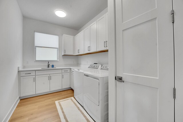13496 Bernoulli Way, Palm Beach Gardens, FL 33418 - washroom with washing machine and clothes dryer, cabinet space, and light wood-style flooring