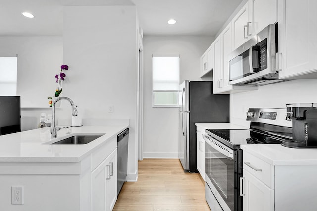 13496 Bernoulli Way, Palm Beach Gardens, FL 33418 - kitchen with appliances with stainless steel finishes, light wood finished floors, a peninsula, white cabinetry, and recessed lighting