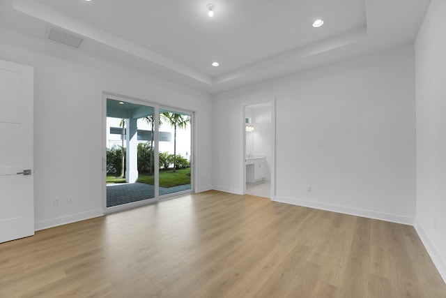 13496 Bernoulli Way, Palm Beach Gardens, FL 33418 - empty room with a raised ceiling, recessed lighting, and light wood finished floors