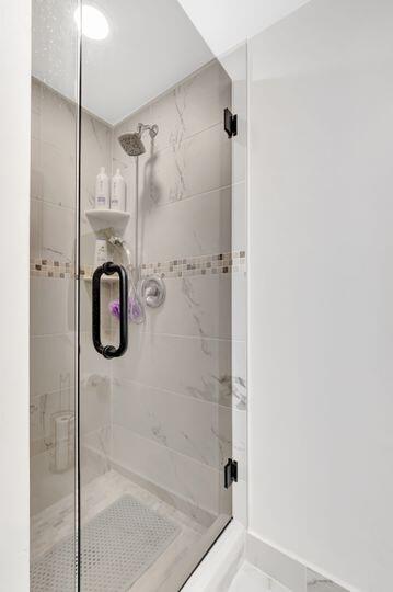 313 Saxony Unit G, Delray Beach, FL 33446 - full bathroom with a shower stall and baseboards