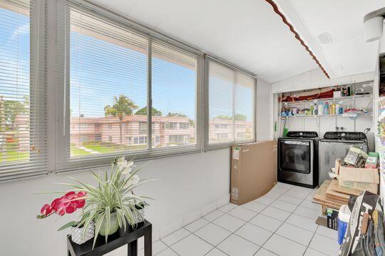 313 Saxony Unit G, Delray Beach, FL 33446 - washroom with washing machine and dryer, healthy amount of natural light, and light tile patterned floors