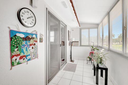 313 Saxony Unit G, Delray Beach, FL 33446 - hallway featuring tile patterned flooring and lofted ceiling