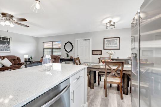 313 Saxony Unit G, Delray Beach, FL 33446 - kitchen with appliances with stainless steel finishes, light wood-type flooring, white cabinetry, ceiling fan, and open floor plan