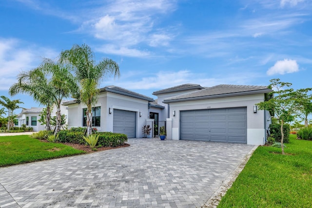 11535 SW Surf Springs Rd, Port Saint Lucie, FL 34987 - view of front of house with a garage, decorative driveway, a front yard, and stucco siding