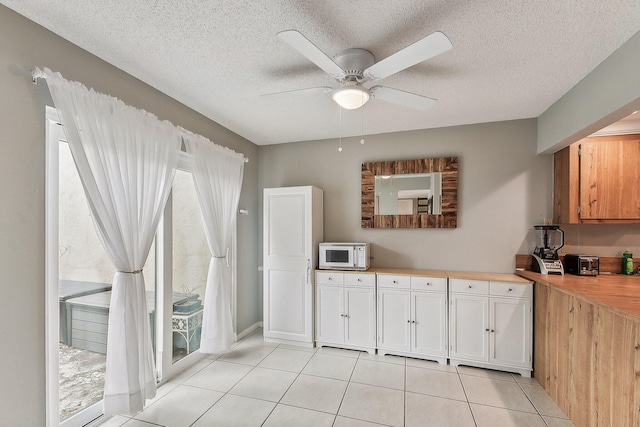 11063 Oakdale Rd, Boynton Beach, FL 33437 - kitchen with white microwave, light countertops, light tile patterned floors, ceiling fan, and a textured ceiling