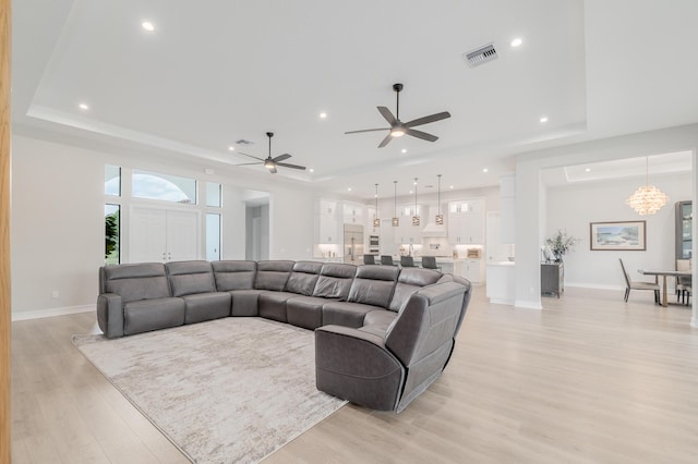 3153 SW Pond Apple St, Palm City, FL 34990 - living area featuring a raised ceiling, light wood-style floors, recessed lighting, ceiling fan, and a chandelier