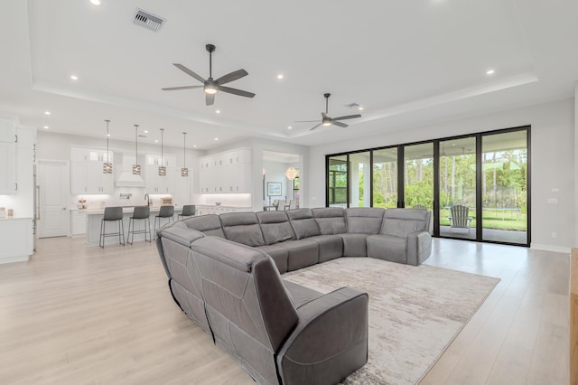 3153 SW Pond Apple St, Palm City, FL 34990 - living area featuring a tray ceiling, ceiling fan, light wood-style floors, and recessed lighting