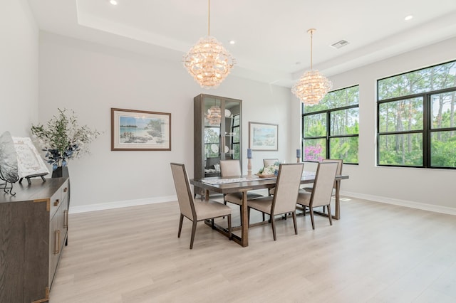 3153 SW Pond Apple St, Palm City, FL 34990 - dining space featuring a chandelier, a tray ceiling, light wood-style floors, plenty of natural light, and recessed lighting