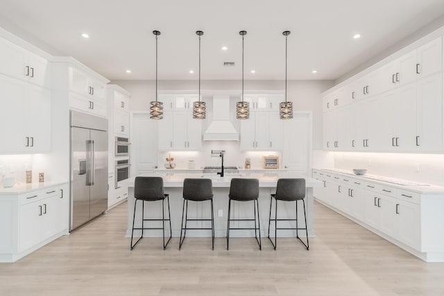 3153 SW Pond Apple St, Palm City, FL 34990 - kitchen featuring stainless steel appliances, a breakfast bar, light wood-style flooring, and recessed lighting