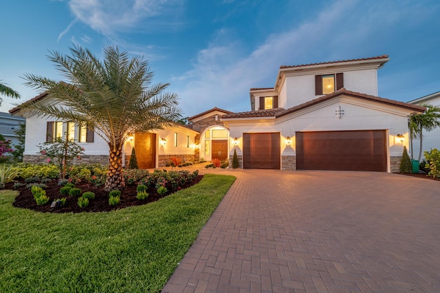 3153 SW Pond Apple St, Palm City, FL 34990 - mediterranean / spanish-style home featuring stone siding, stucco siding, decorative driveway, and an attached garage
