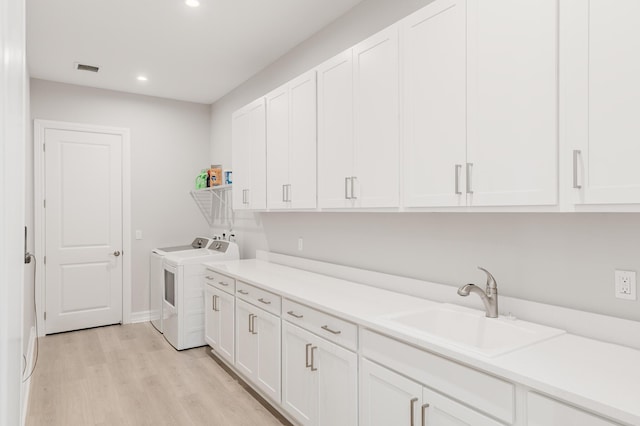 3153 SW Pond Apple St, Palm City, FL 34990 - laundry room featuring washing machine and clothes dryer, cabinet space, recessed lighting, and light wood-style flooring