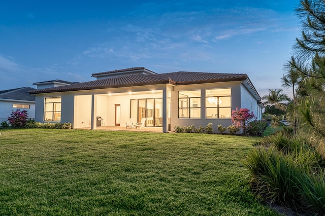 3153 SW Pond Apple St, Palm City, FL 34990 - back of house featuring stucco siding, a lawn, a tile roof, and a patio