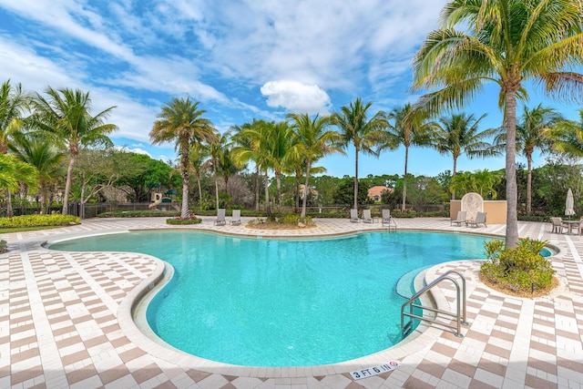 3153 SW Pond Apple St, Palm City, FL 34990 - community pool featuring a patio area and view of wooded area