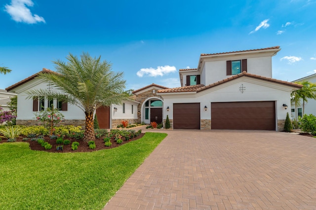 3153 SW Pond Apple St, Palm City, FL 34990 - mediterranean / spanish home with stone siding, stucco siding, decorative driveway, an attached garage, and a front yard
