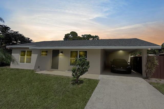 216 SE Fallon Dr, Port Saint Lucie, FL 34983 - ranch-style home featuring concrete driveway, stucco siding, an attached carport, and a shingled roof