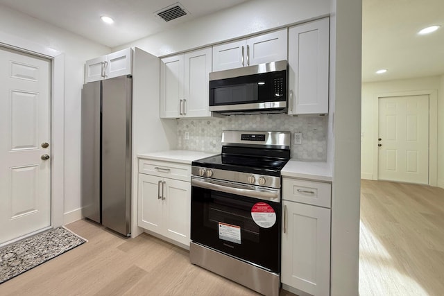 216 SE Fallon Dr, Port Saint Lucie, FL 34983 - kitchen featuring stainless steel appliances, light wood-style flooring, light countertops, decorative backsplash, and recessed lighting