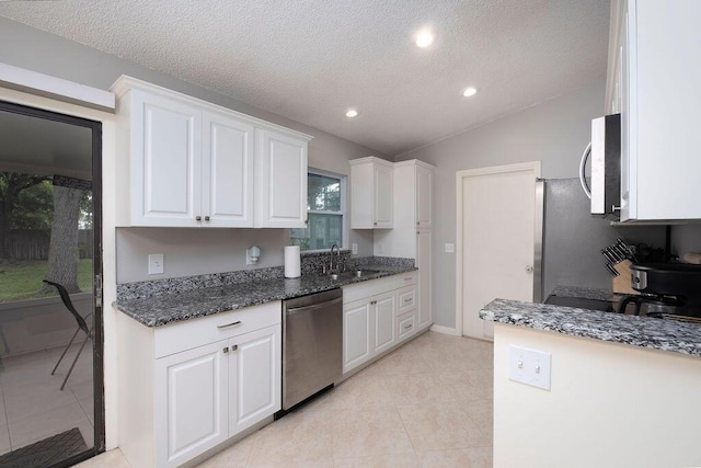 1967 SW Ember St, Port Saint Lucie, FL 34953 - kitchen featuring appliances with stainless steel finishes, white cabinets, light tile patterned floors, a textured ceiling, and dark stone countertops