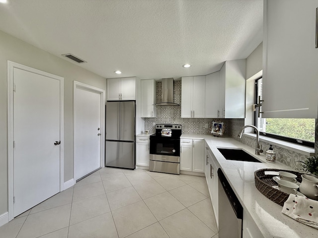 9890 Pecan Tree Dr Unit B, Boynton Beach, FL 33436 - kitchen featuring stainless steel appliances, wall chimney exhaust hood, decorative backsplash, light stone countertops, and a textured ceiling