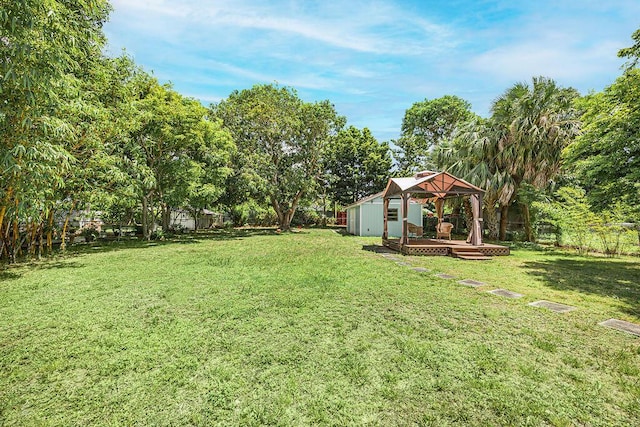 1606 16th Ave N, Lake Worth Beach, FL 33460 - fenced backyard featuring a gazebo, a wooden deck, an outdoor structure, and view of wooded area