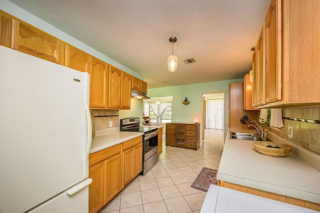 1606 16th Ave N, Lake Worth Beach, FL 33460 - kitchen featuring freestanding refrigerator, stainless steel electric range oven, tasteful backsplash, under cabinet range hood, and light countertops