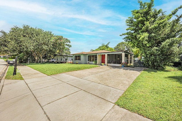 1606 16th Ave N, Lake Worth Beach, FL 33460 - view of front of house featuring driveway, a sunroom, and a front lawn