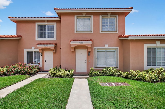 9850 Kamena Cir, Boynton Beach, FL 33436 - view of front of home featuring a tile roof, a front lawn, and stucco siding