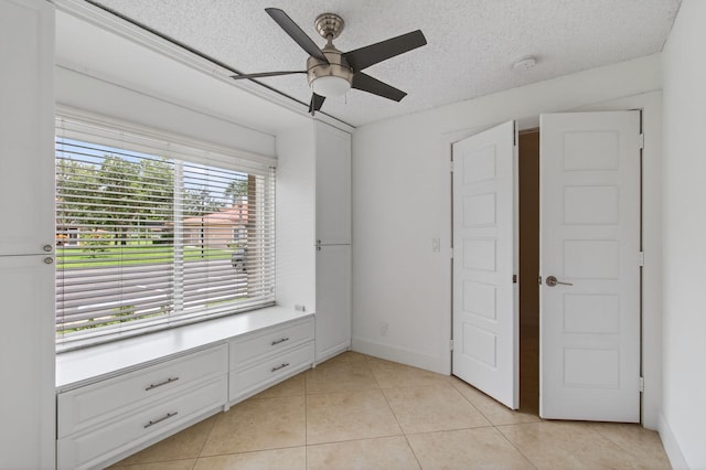 9850 Kamena Cir, Boynton Beach, FL 33436 - unfurnished bedroom with light tile patterned floors, a textured ceiling, and a ceiling fan
