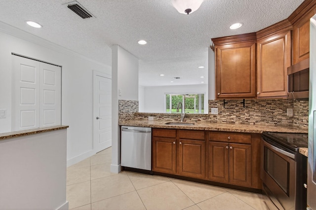 9850 Kamena Cir, Boynton Beach, FL 33436 - kitchen featuring appliances with stainless steel finishes, brown cabinets, a textured ceiling, decorative backsplash, and light tile patterned floors