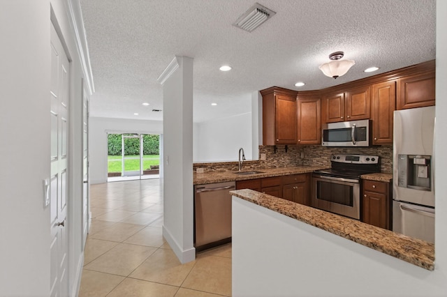 9850 Kamena Cir, Boynton Beach, FL 33436 - kitchen with stainless steel appliances, light tile patterned flooring, backsplash, stone countertops, and a textured ceiling