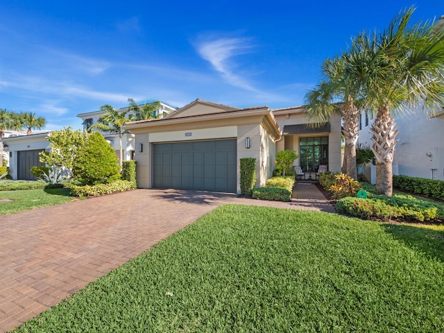 13058 Artisan Cir, Palm Beach Gardens, FL 33418 - single story home with decorative driveway, a front yard, a garage, and stucco siding