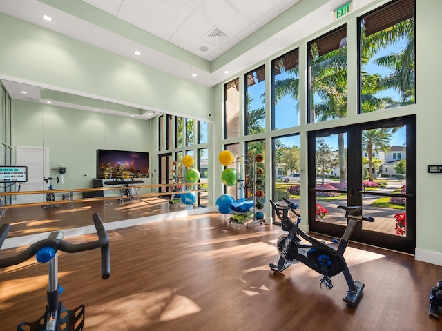 13058 Artisan Cir, Palm Beach Gardens, FL 33418 - gym featuring french doors, a high ceiling, wood finished floors, and a paneled ceiling