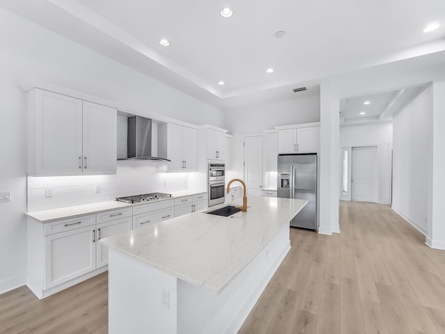 13058 Artisan Cir, Palm Beach Gardens, FL 33418 - kitchen with stainless steel appliances, wall chimney exhaust hood, white cabinetry, light wood-style floors, and decorative backsplash