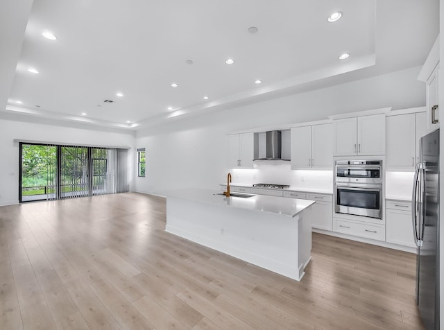 13058 Artisan Cir, Palm Beach Gardens, FL 33418 - kitchen with a tray ceiling, wall chimney exhaust hood, appliances with stainless steel finishes, open floor plan, and backsplash