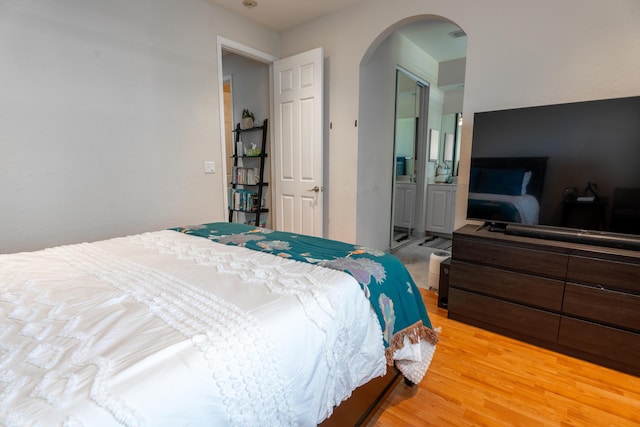 161 Lake Monterey Cir, Boynton Beach, FL 33426 - bedroom with arched walkways, light wood-style floors, and ensuite bath
