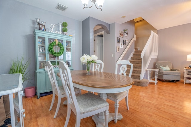 161 Lake Monterey Cir, Boynton Beach, FL 33426 - dining room featuring light wood finished floors, arched walkways, stairway, and a chandelier