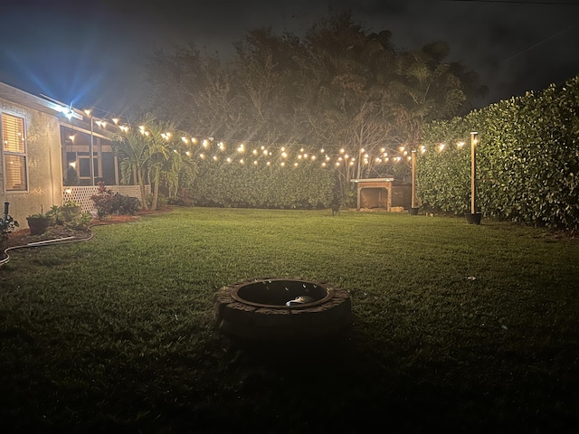 2457 SE Shipping Rd, Port Saint Lucie, FL 34952 - yard at night featuring a lawn and an outdoor fire pit