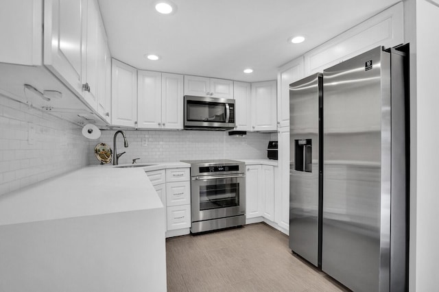 8291 Thames Blvd Unit C, Boca Raton, FL 33433 - kitchen with appliances with stainless steel finishes, white cabinetry, light countertops, recessed lighting, and backsplash