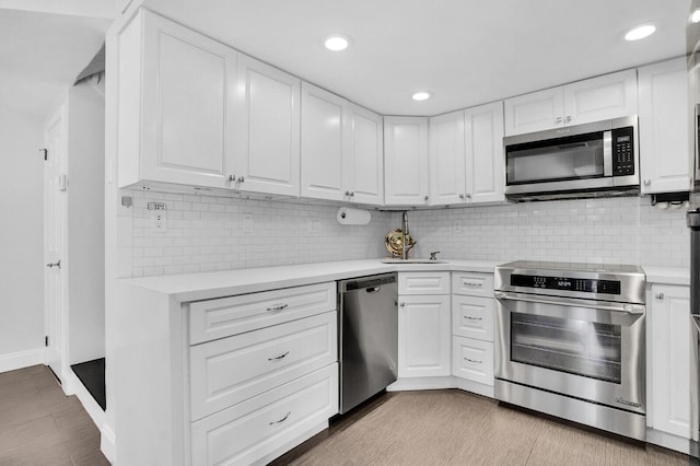 8291 Thames Blvd Unit C, Boca Raton, FL 33433 - kitchen featuring appliances with stainless steel finishes, light countertops, white cabinets, decorative backsplash, and recessed lighting