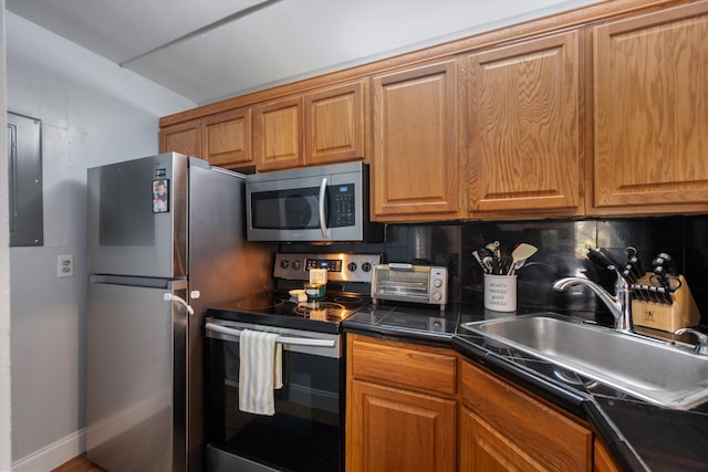 624 Sea Pine Way Unit A2, Greenacres, FL 33415 - kitchen featuring stainless steel appliances, dark countertops, brown cabinets, electric panel, and tasteful backsplash