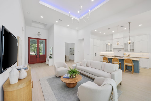 737 Nighthawk Way, North Palm Beach, FL 33408 - living area with a high ceiling, light wood-type flooring, recessed lighting, and a raised ceiling