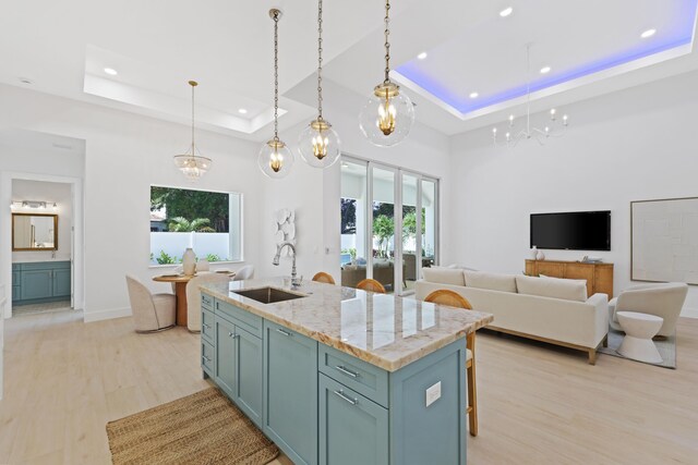 737 Nighthawk Way, North Palm Beach, FL 33408 - kitchen featuring a tray ceiling, light wood-style floors, recessed lighting, open floor plan, and hanging light fixtures