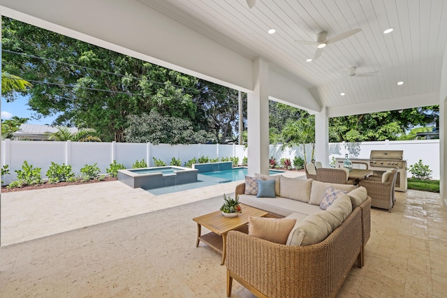 737 Nighthawk Way, North Palm Beach, FL 33408 - fenced backyard with a grill, a patio area, outdoor lounge area, a ceiling fan, and a pool with connected hot tub