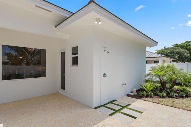 737 Nighthawk Way, North Palm Beach, FL 33408 - view of exterior entry with a patio area, a standing seam roof, stucco siding, and a metal roof