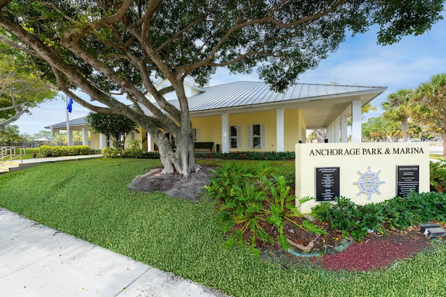 737 Nighthawk Way, North Palm Beach, FL 33408 - view of front of home with stucco siding, a front lawn, a metal roof, and a standing seam roof