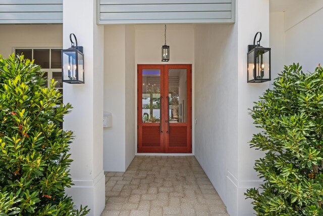 737 Nighthawk Way, North Palm Beach, FL 33408 - view of exterior entry featuring stucco siding, a lawn, and french doors